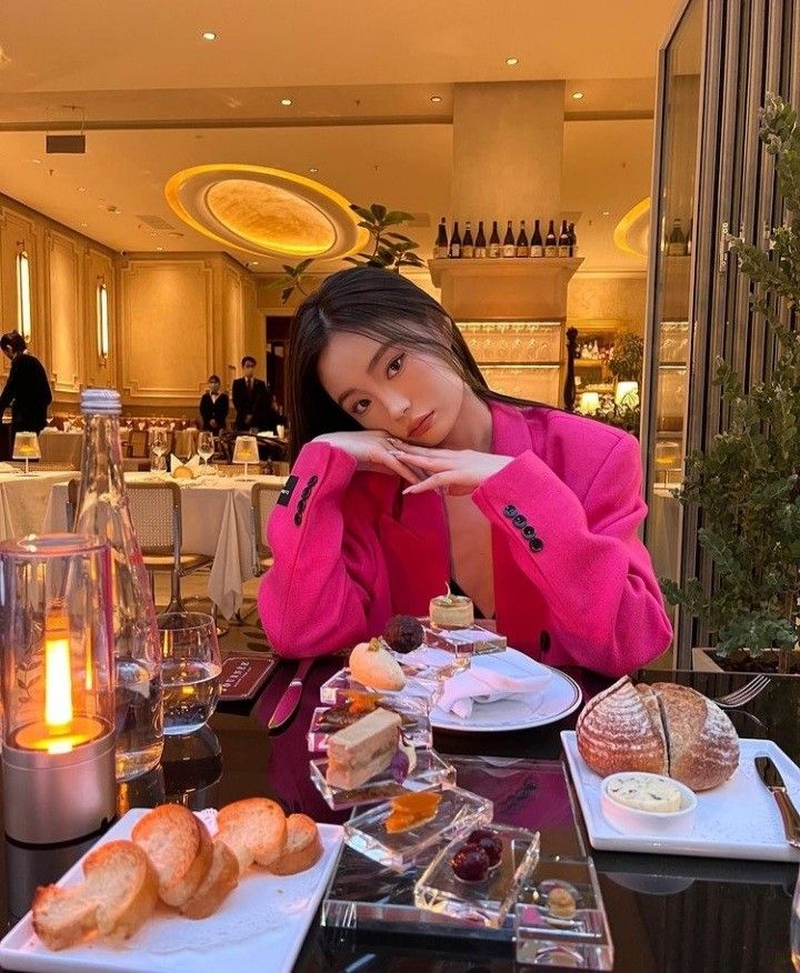 a woman sitting at a table with food on it