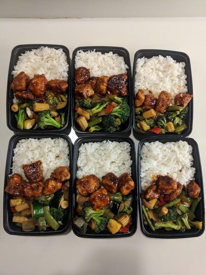 six plastic trays filled with rice and meat next to broccoli on top of each other