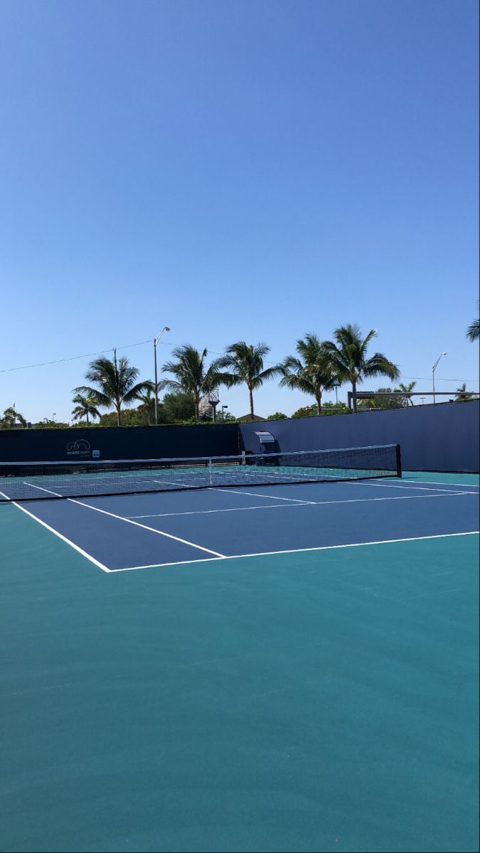 the tennis court is empty and ready for people to play on or off in it