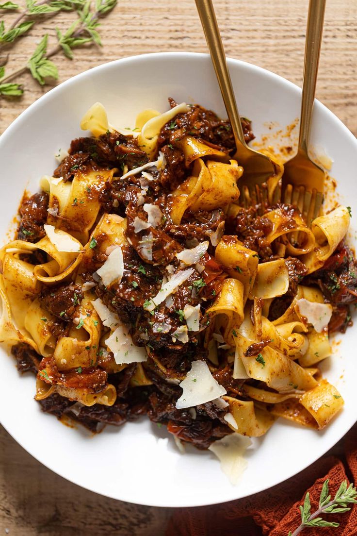 a white bowl filled with pasta and meat