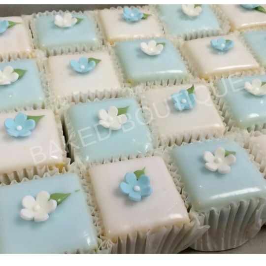 some blue and white square shaped cakes with flowers on them are ready to be eaten