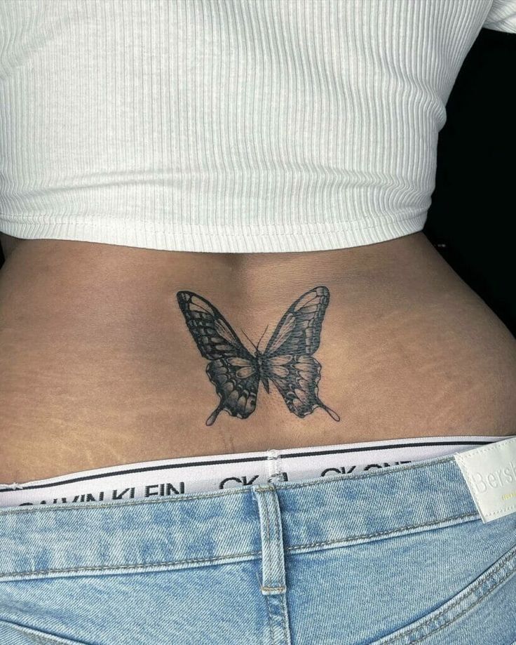 a woman's stomach with a butterfly tattoo on her lower back, and the bottom half