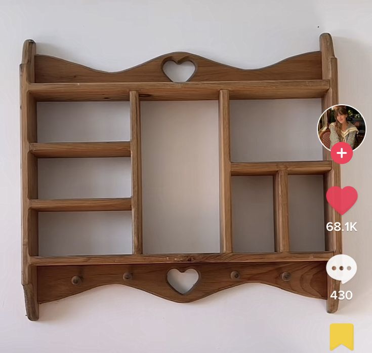 a wooden shelf with several compartments and hearts on the bottom, along with an instagram sticker