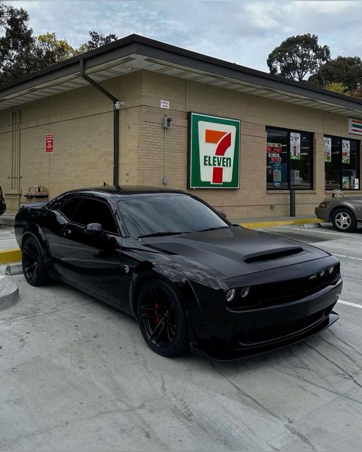 a black car parked in front of a gas station