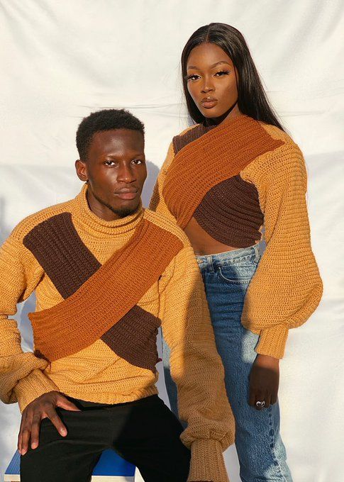 two people standing next to each other in front of a white backdrop wearing sweaters