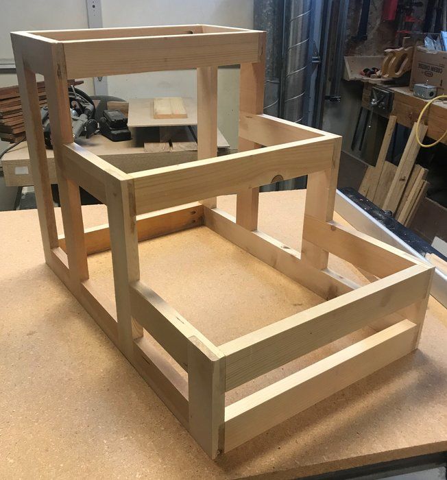 a wooden chair sitting on top of a table next to a piece of plywood