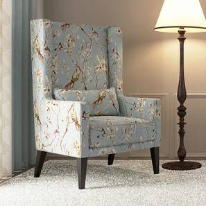 a blue chair sitting next to a lamp on top of a white carpeted floor