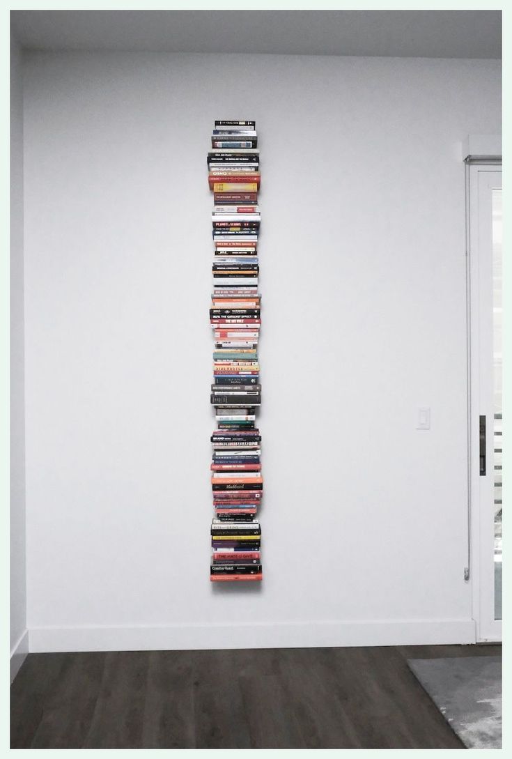 a stack of dvd's on the wall in an empty room with wood flooring