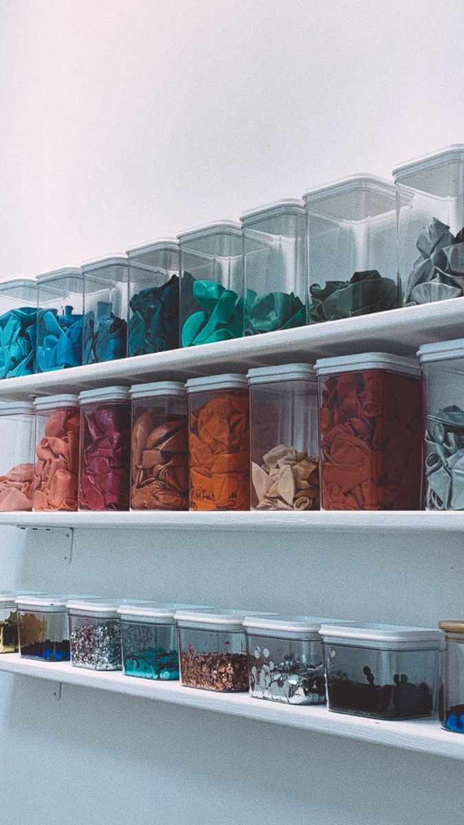 the shelves are filled with many different colored containers and bins on top of each other