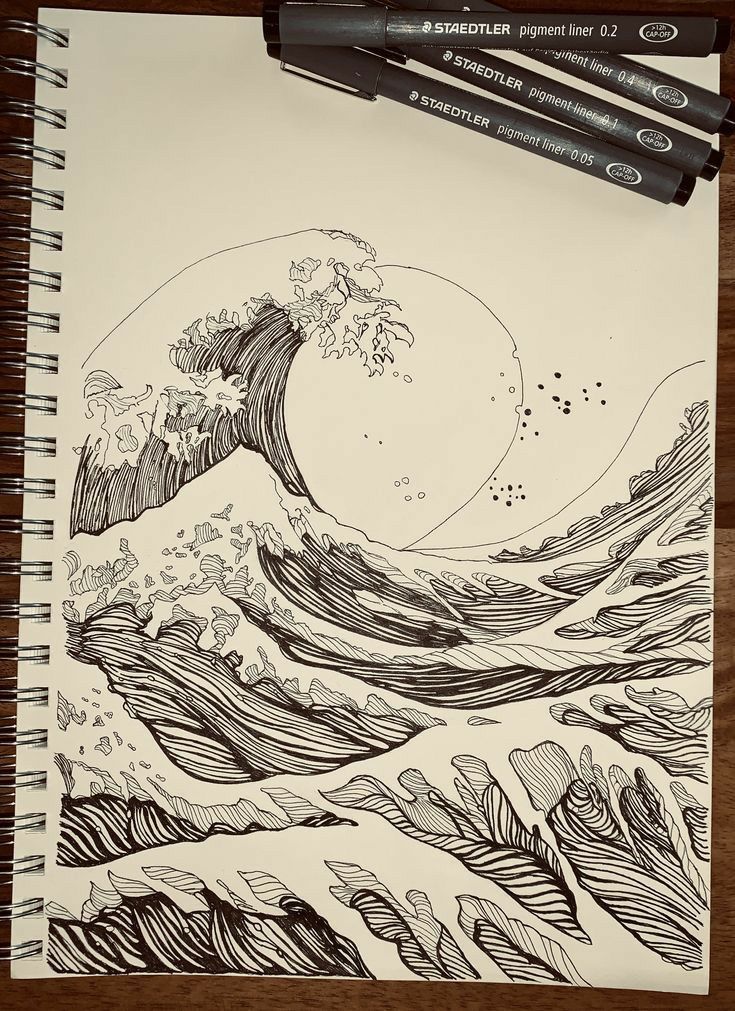 a drawing of the great wave in black and white on paper with two markers next to it