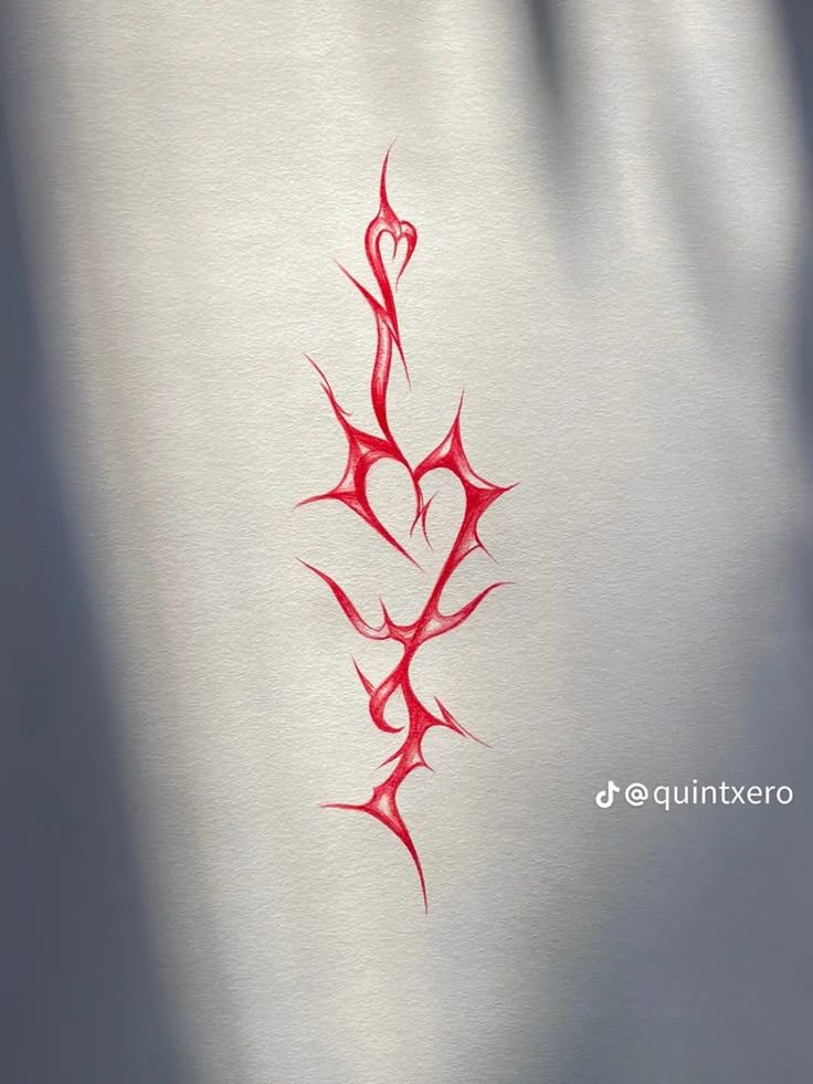 a red tattoo design on the side of a white paper with a heart in it