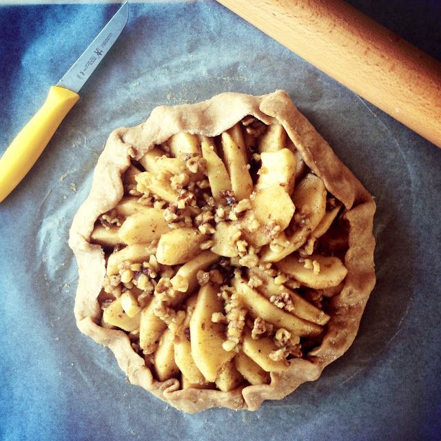 an uncooked pie sitting on top of a blue cloth next to a knife