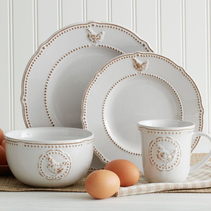 an assortment of white dishes and eggs on a table