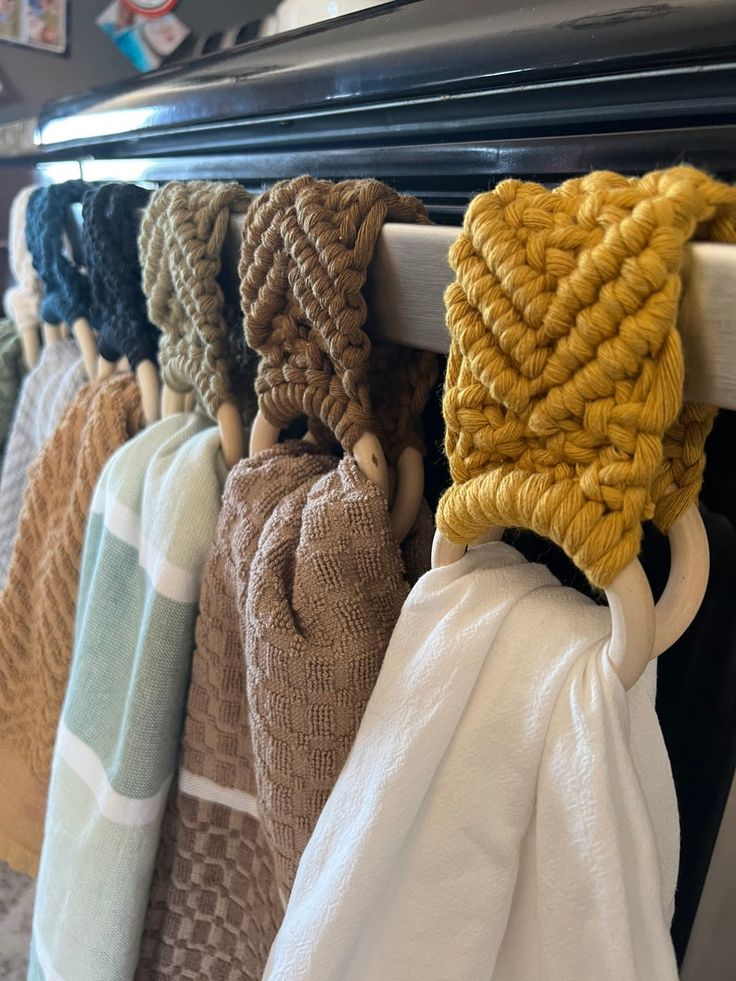 several towels hanging on a rack in front of a stove with the handles pulled up