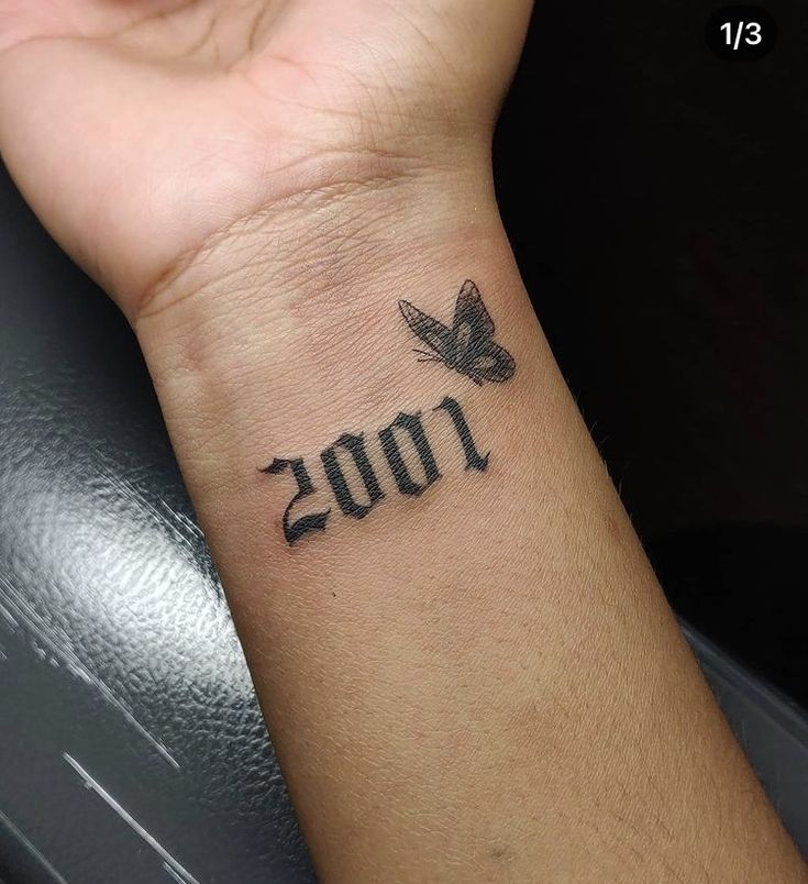 a person with a tattoo on their wrist that reads 200 and has a butterfly in the middle