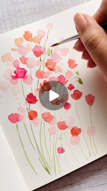 someone is painting flowers with watercolors on paper