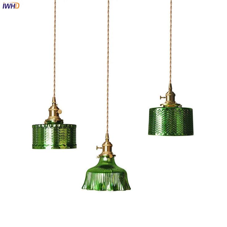 three green glass pendant lights hanging from cords