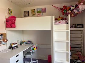 there is a loft bed with desk underneath it