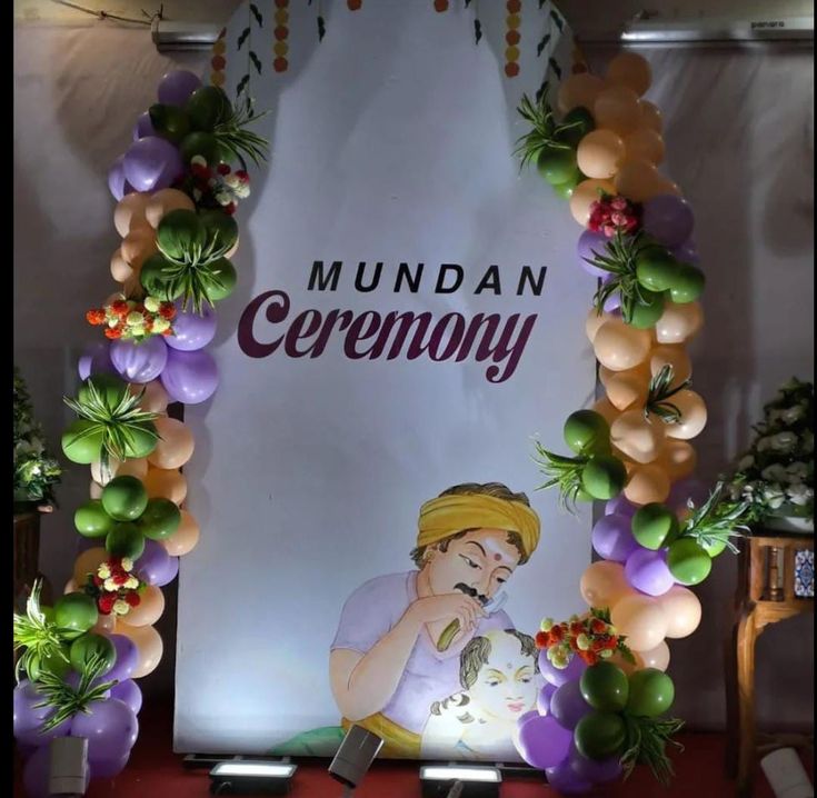 a sign that reads mundaan ceremony with balloons and flowers around the front wall