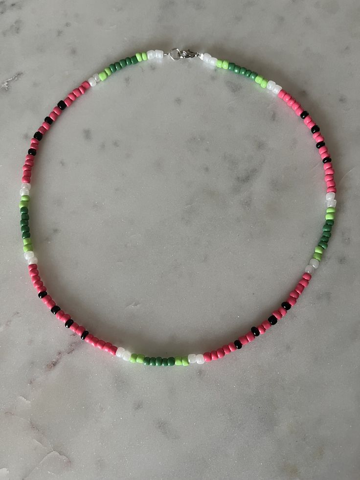 a multicolored beaded necklace on a marble surface