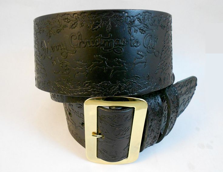 two black leather belts with gold buckles on white background, one has the words merry christmas written on it