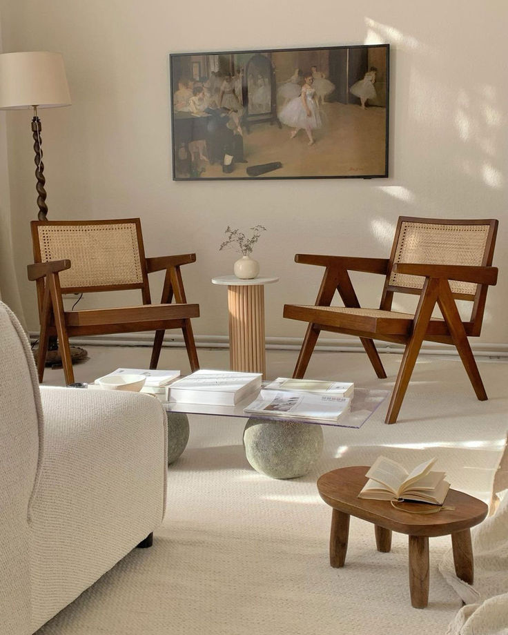 a living room filled with furniture and a painting on the wall