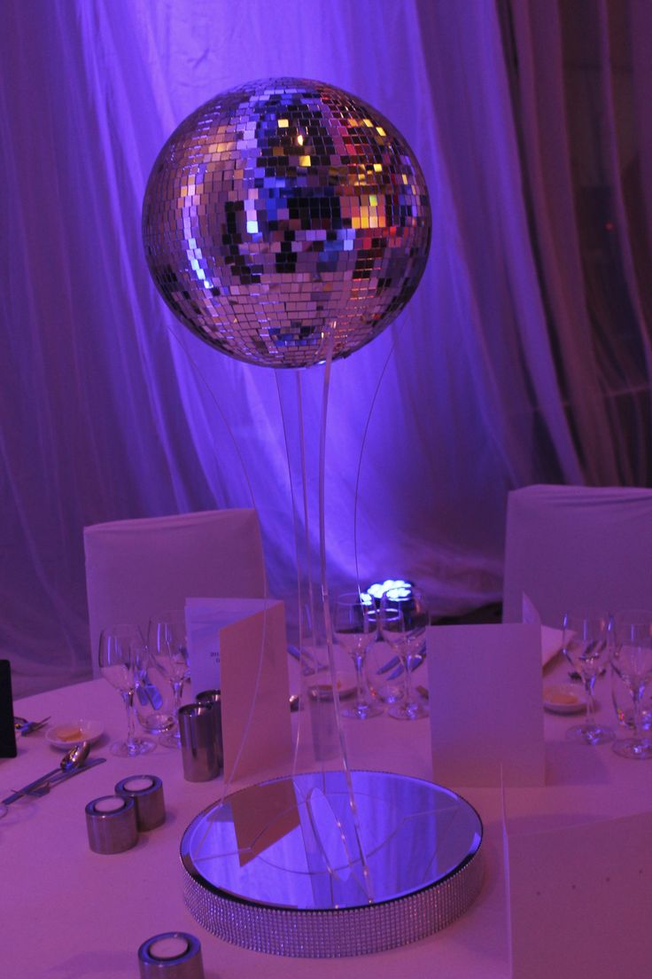 a table topped with a disco ball and place settings