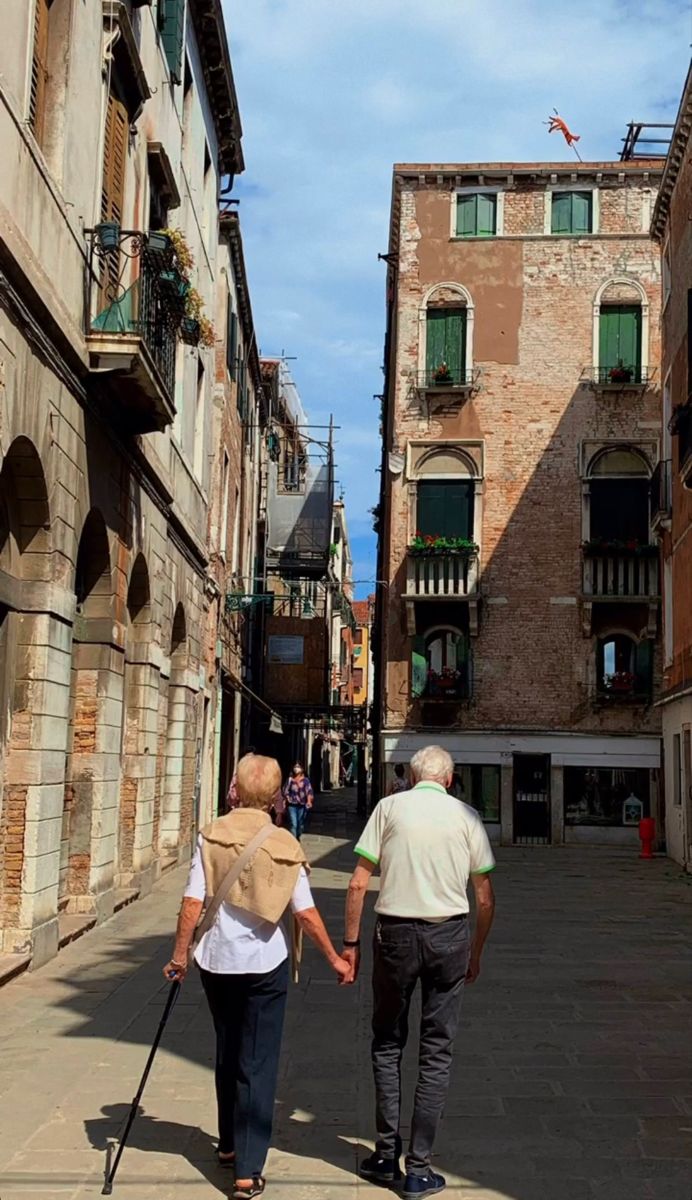 an older couple walking down the street holding hands