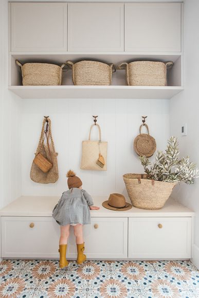 a white shelf with baskets and bags on it