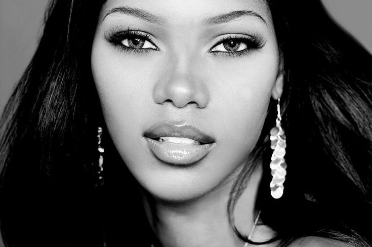 a black and white photo of a woman with long dark hair wearing large hoop earrings