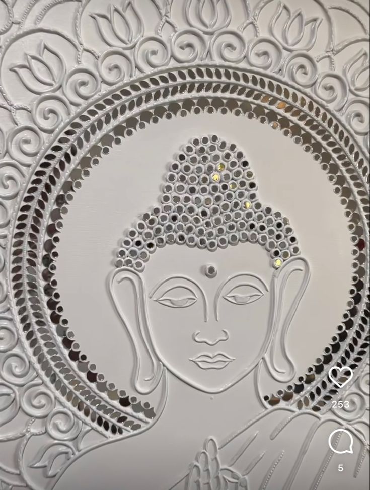 an intricately designed glass plate with a buddha face on it's side, in white