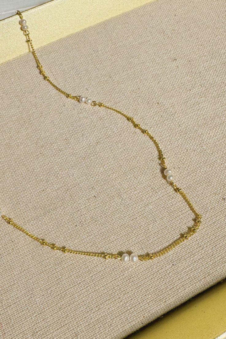 Introducing the epitome of understated elegance: a dainty bead pearl necklace that marries the timeless charm of pearls with the delicate allure of fine gold chain. Each pearl is carefully selected and spaced along the golden strand, creating a symphony of subtle sophistication that dances gracefully upon the neck. Perfect for layering or as a standalone piece, this necklace is a celebration of classic style, making it an essential addition to any jewelry collection. Delicate Gold Pearl Chain Necklace, Elegant Wedding Necklace With Satellite Chain, Gold Necklaces With Satellite Chain For Wedding, Dainty Pearl Necklace With Beaded Chain, Gold Pearl Necklace With Beaded Chain For Wedding, Delicate Pearl Necklace With Delicate Chain, Dainty Gold Chain Necklace With Pearls, Gold Dainty Pearl Drop Necklace, Dainty Pearl Necklace With Pearl Chain