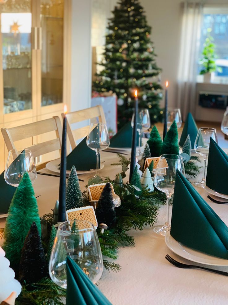 the table is set with green napkins and place settings for christmas dinner guests to enjoy