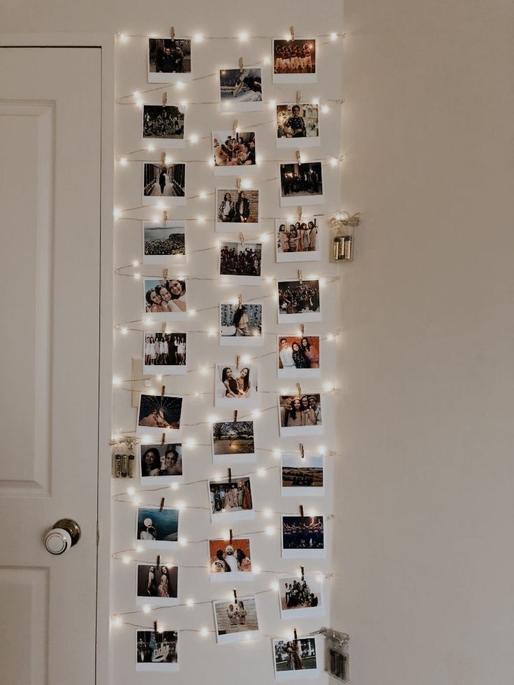 a wall with pictures and lights hanging from it's sides in front of a door