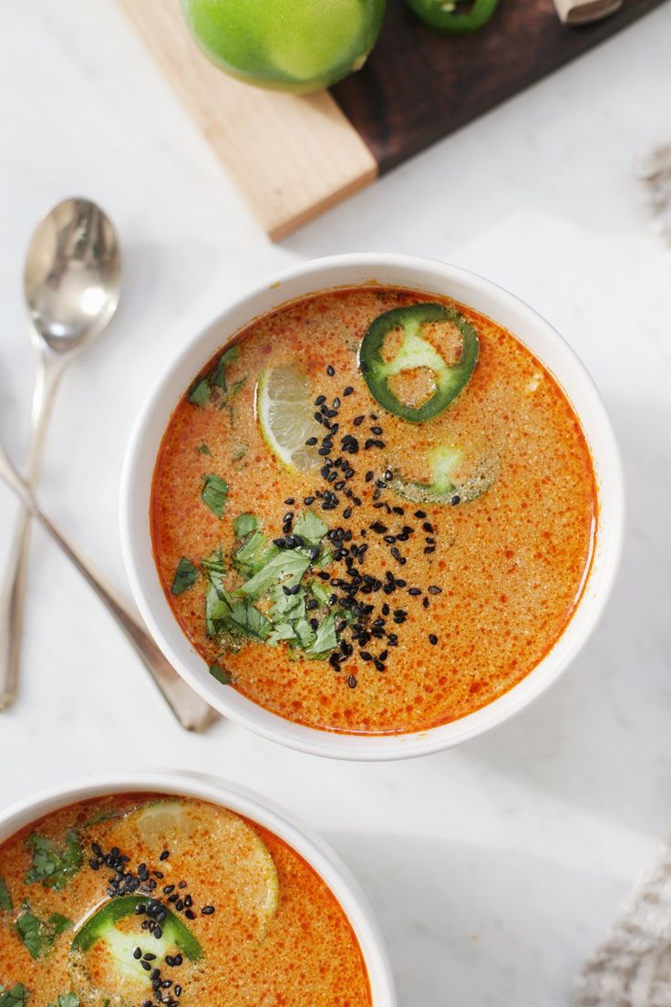 two bowls filled with soup on top of a table