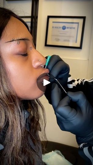 a woman getting her teeth brushed by a dentist