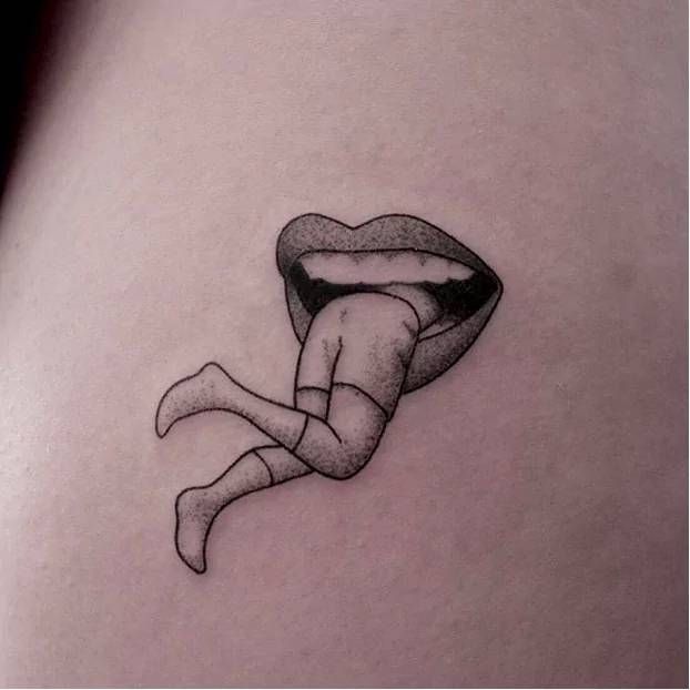 a woman's stomach with a tattoo of a mouth and tongue on the side