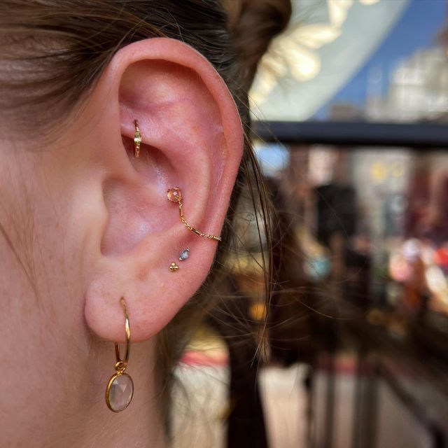 a close up of a person's ear with two small earrings on top of it