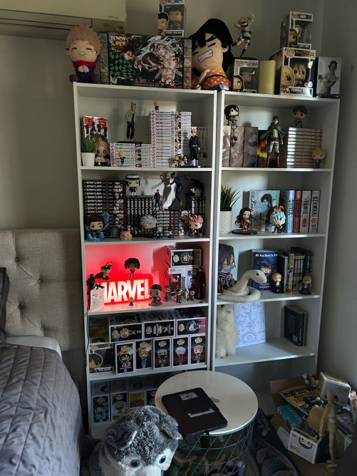 a bed room with a book shelf filled with books and stuffed animals on top of it