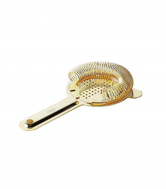 a golden metal strainer on a white background