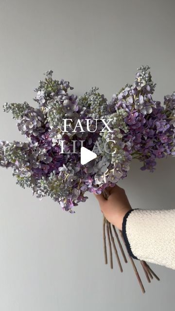 a person holding flowers in their hand with the words faux it up on top of them