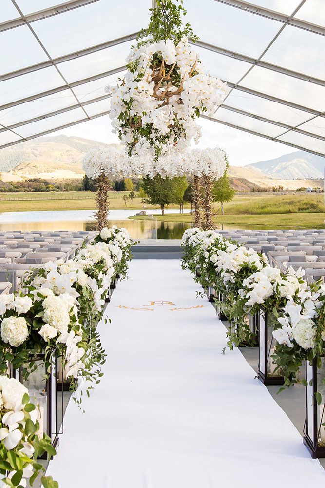 an outdoor wedding setup with white flowers and greenery