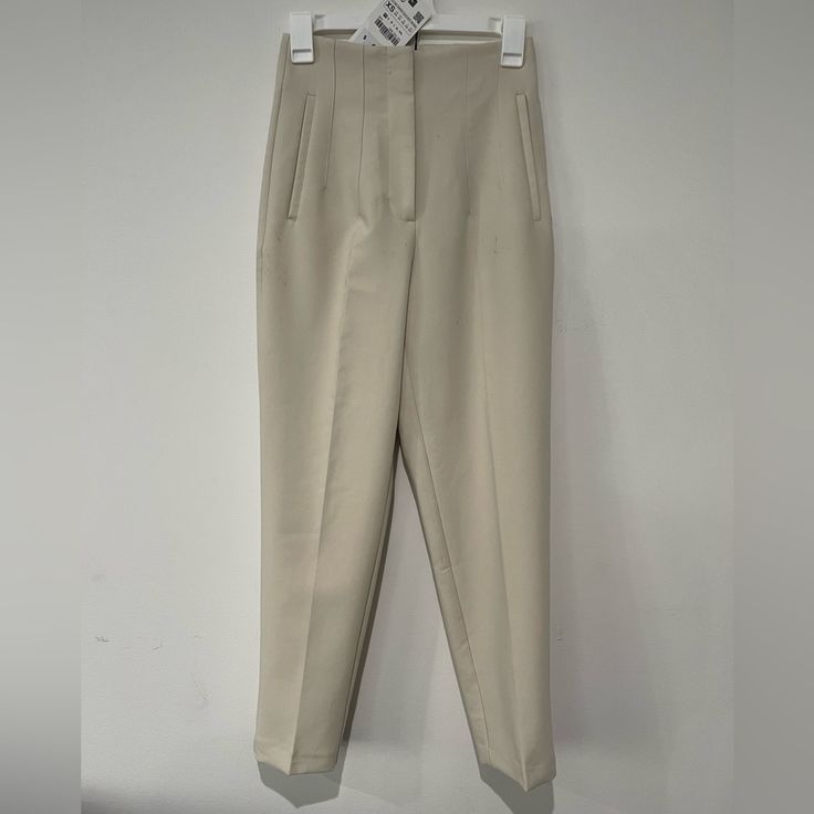 *Please Note Some Dirty Spots* High Waisted Pants With Pronounced Seams At Front And Back. Front Welt Pockets. Front Zip, Metal Hook, And Inside Button Closure. Oyster White Xs Beige Office Bottoms With Pockets, Cream Ankle-length Workwear Bottoms, Cream Ankle-length Pants For Workwear, Ankle-length Cream Bottoms For Workwear, Cream Workwear Ankle-length Bottoms, Elegant Neutral Pants With Belt Loops, Cream Straight Pants With Belt Loops, Cream Pants With Belt Loops For Work, Cream Straight Pants For Work