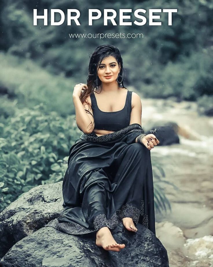 a woman sitting on top of a rock next to a river