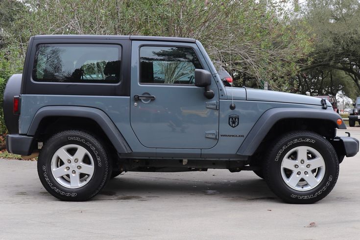 a gray jeep is parked in a parking lot