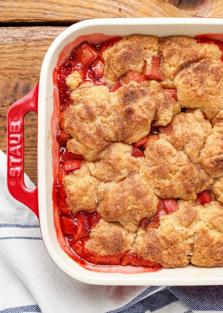 a close up of a casserole dish with strawberries in it on a table