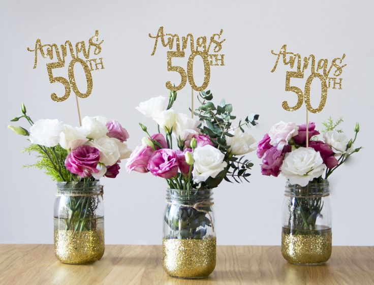 three mason jars with flowers in them on a table