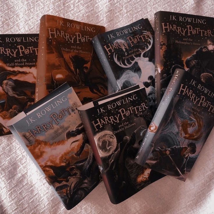 five harry potter books lined up on a bed