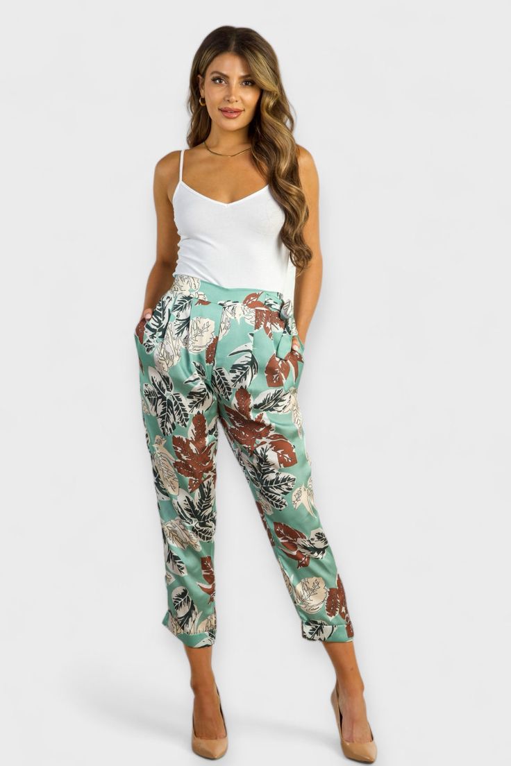 Effortlessly chic, the Anna Floral Satin Trousers are a must-have for any fashion-forward individual. Made in Italy from lightweight and cool fabric, these trousers feature a pull-on style with an elastic back waist for ultimate comfort. With a self-tie belt for an easy and adjustable fit, a high-rise waist, tapered leg, and fold-over hem, these trousers also come equipped with side pockets for added convenience. Complete the look with our Vera Striped Blazer for a stylish and coordinated outfit Chic Summer Rayon Pants, Chic Rayon Pants For Summer, Chic Harem Pants With Pockets For Vacation, Versatile Tapered Leg Pants For Day Out, Floral Print Wide Leg Bottoms In Viscose, Green Viscose Casual Bottoms, Spring Viscose Loungewear Pants, Spring Viscose Pants For Loungewear, Casual Green Viscose Bottoms