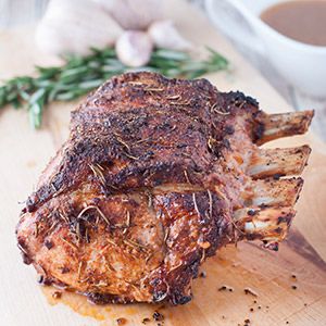 a piece of meat sitting on top of a wooden cutting board next to a cup of coffee